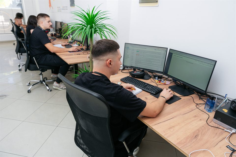 A colleague working with two monitors in the shared office