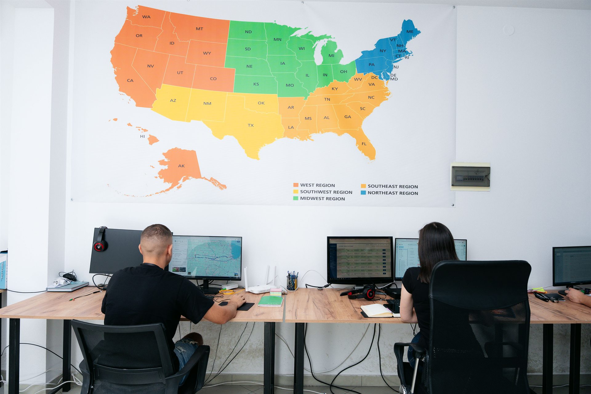 Office workstations beneath a large map of the United States