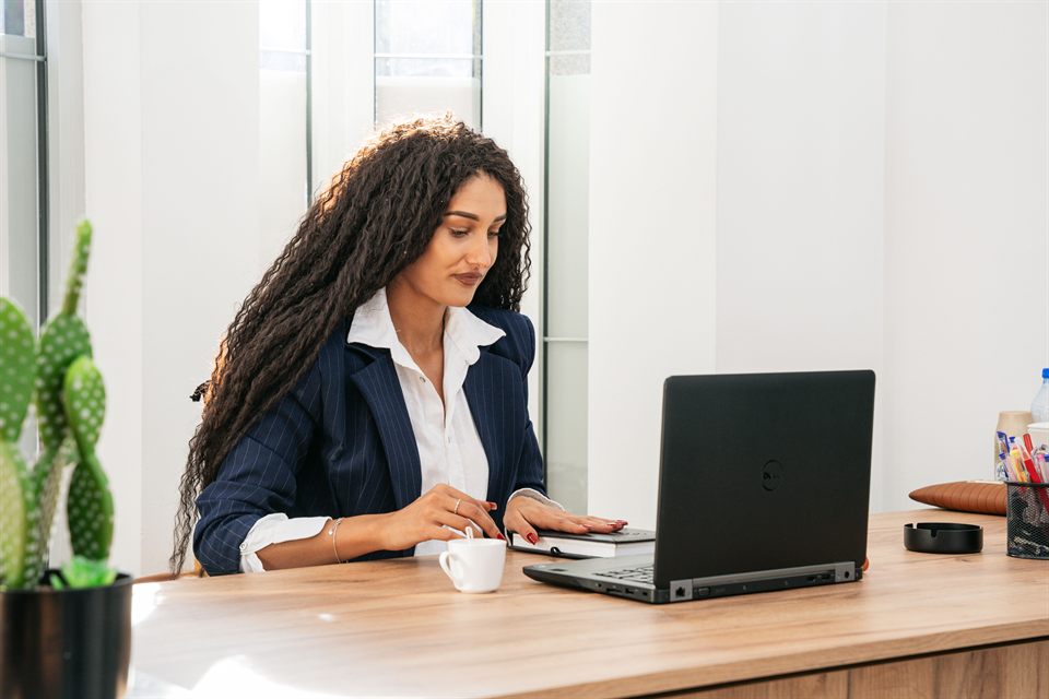 A colleague reviewing paperwork beside a laptop
